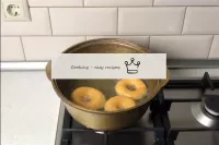 Fry the doughnuts over a low heat until golden bro...