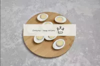 Отваренные яйца очистите от скорлупы и разрежьте н...
