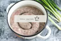 Place a mug of raw sausage in a saucepan or cauldr...