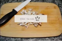 用刀在切割板上研磨蘑菇腿。...