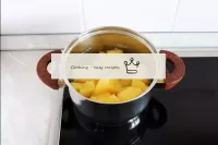 Kartoffeln mit einer Bürste unter fließendem Wasse...