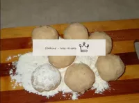 チーズをジャガイモの塊のスプーンに入れ、ボールを転がします。小麦粉でボールをロール。...