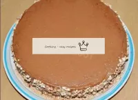 Die Ränder der Torte werden mit zerkleinerten Nüss...