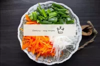 Grate carrots and daikon on a vegetable cutter for...