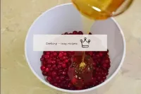 将干浆果转移到单独的盘子中，倒入蜂蜜中。即使蜂蜜被撒上，也要添加，不要融化。随后与蔓越莓汁混合并溶解...