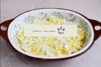对于一捆层，加入一些磨碎的奶酪。清洗洋葱，将洋葱切成薄片。将切碎的洋葱撒在土豆上。...