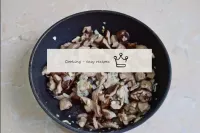 在煎锅中加入蘑菇的洋葱。一起油炸5-7分钟。在这段时间里，水分会从真菌中蒸发，它们会开始稍微卷曲。...