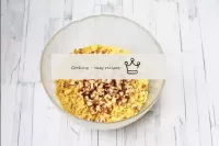In a bowl, combine the cornflakes and crushed nuts...
