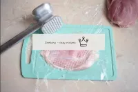 要击退，将肉片放在板上，盖上保鲜膜。用烹饪锤立即在胶片上敲击肉。胶片将防止肉汁溅出，切片的边缘在击退...