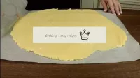 Roll the dough between two sheets of parchment int...
