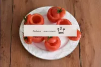 Wash the tomatoes, dry. Cut off the tops and caref...