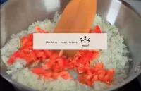 將一個西紅柿預切成小塊的洋蔥煎鍋，攪拌繼續烤蔬菜。...