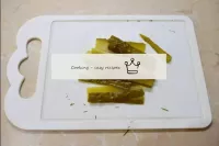 Tagliate con le strisce il cetriolo salato. ...