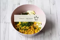 在一个碗里，连接鱿鱼，罐装玉米，鸡蛋和一些切碎的蔬菜。...