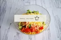 In a salad bowl, combine crab sticks, tomatoes, cu...