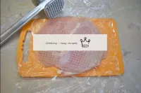 Place the meat on a board and cover with cling fil...