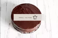 把蛋糕倒在上面剩下的巧克力釉料上，也散布在蛋糕的側面。...