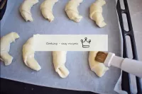 Die Oberfläche aller Croissants gleichmäßig mit Ei...