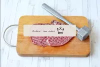 Os pedaços de carne bovina são batidos de dois lad...