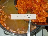 この時までに、鍋の中のジャガイモはすでに沸騰しており、トマトの中のタマネギと一緒にソーセージを鍋に移...
