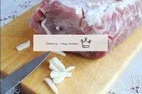 豚肉を洗ってペーパータオルでよく流す。ニンニクの皮をむき、長い棒に切る。鋭利なナイフで肉に、ニンニク...