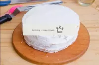 De tous les côtés, planter le gâteau avec de la cr...