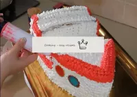 蛋糕的上面用紅色奶油裝飾。...