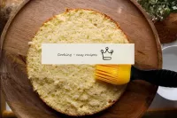 Put the first cake on a flat surface. Brush it wit...