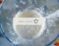 Pour in the sifted flour. Gently stir the dough wi...