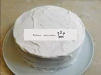 Assemble the cake by profusely coating the top and...