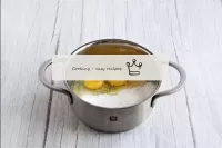 鍋に、卵、砂糖とデンプンを組み合わせます。しこりが消えるまで泡立て器ですべてをかき混ぜる。...
