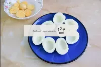 Peel the boiled eggs from the shell and cut each o...