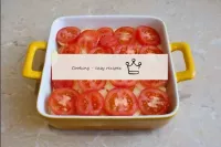 將西紅柿切成杯子，在馬鈴薯的整個表面上鋪設均勻的層。西紅柿也可以調味一些。用鋁箔蓋上形狀，放在預熱至...