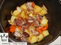 その後、鍋や鍋に肉と野菜を層に入れます。...