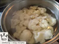 Cauliflower is laid out in a saucepan, poured with...