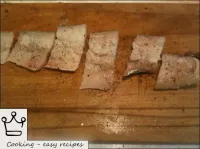 Cod fillet is cut into portions, sprinkled with sa...