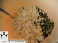 將洋蔥與切碎的煮雞蛋，融化的黃油，鹽和細切的綠色混合在一起。...