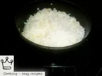 Turn on the oven. Put a saucepan with rice in a mo...