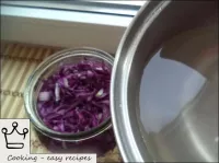 Cabbage is poured with marinade in a jar. ...