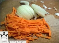 Zwiebeln und Karotten schälen, waschen und in dünn...
