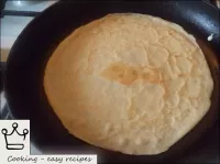 Thin pancakes are baked over medium heat until gol...