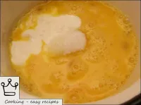 Batir los huevos y mezclar con crema agria, azúcar...
