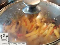 将胡萝卜和土豆加入番茄酱中的肉中。之后，倒入一些水（约100毫升），撒盐（1汤匙盐），撒上香料，搅拌...