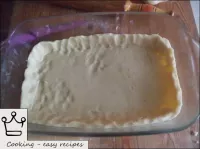 ベーキングシートに生地を置きます。卵（卵黄）でケーキの端を磨き、生地から側面を作ります。...